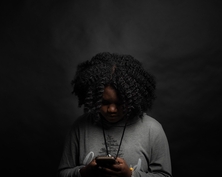 A young girl looking over her phone
